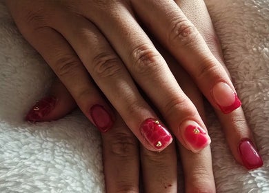 Stylish red manicured nails at NailsByKrista in Newmarket, England, GB showcasing elegant designs.