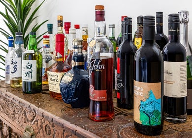 A variety of elegant bottles on a carved wooden shelf at Dapper Man London, West Wollongong, New South Wales, AU.