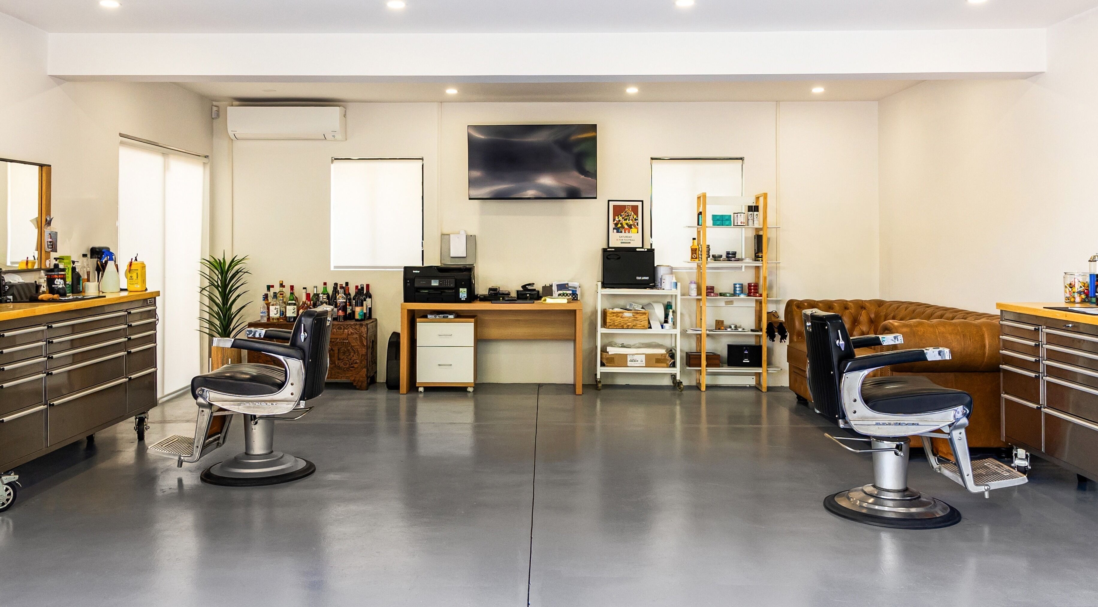 Modern barber interior at Dapper Man London, West Wollongong, New South Wales, AU with stylish chairs and decor.