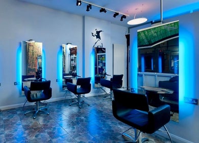 Modern salon interior with blue-lit mirrors at Keir at Aldwick Hair, Bognor Regis, England, GB.