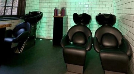Modern wash stations at Keir at Aldwick Hair in Bognor Regis, England, GB, featuring sleek black chairs.