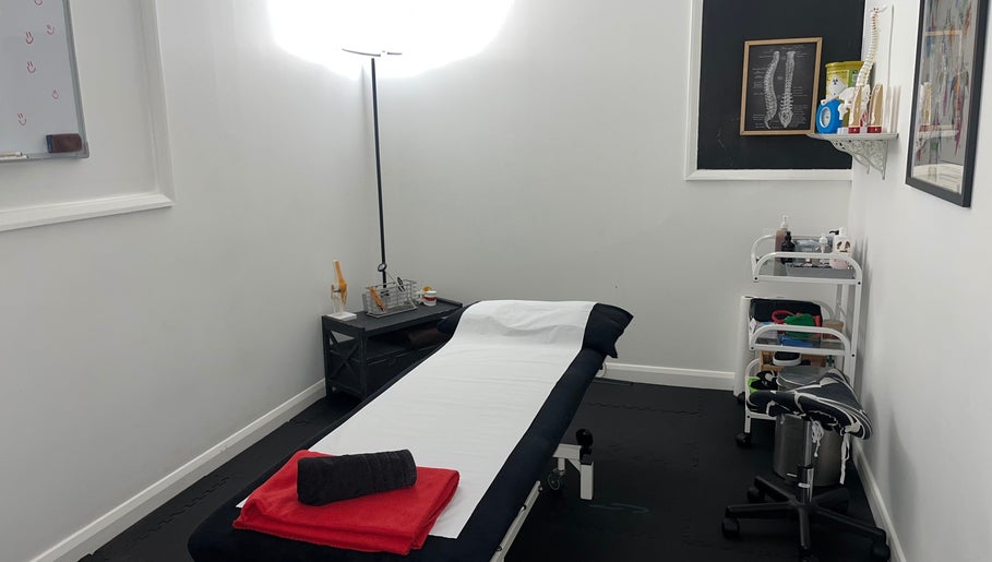 Therapy room at Physio Edge Films, London, England, GB, featuring a treatment table and wellness supplies.