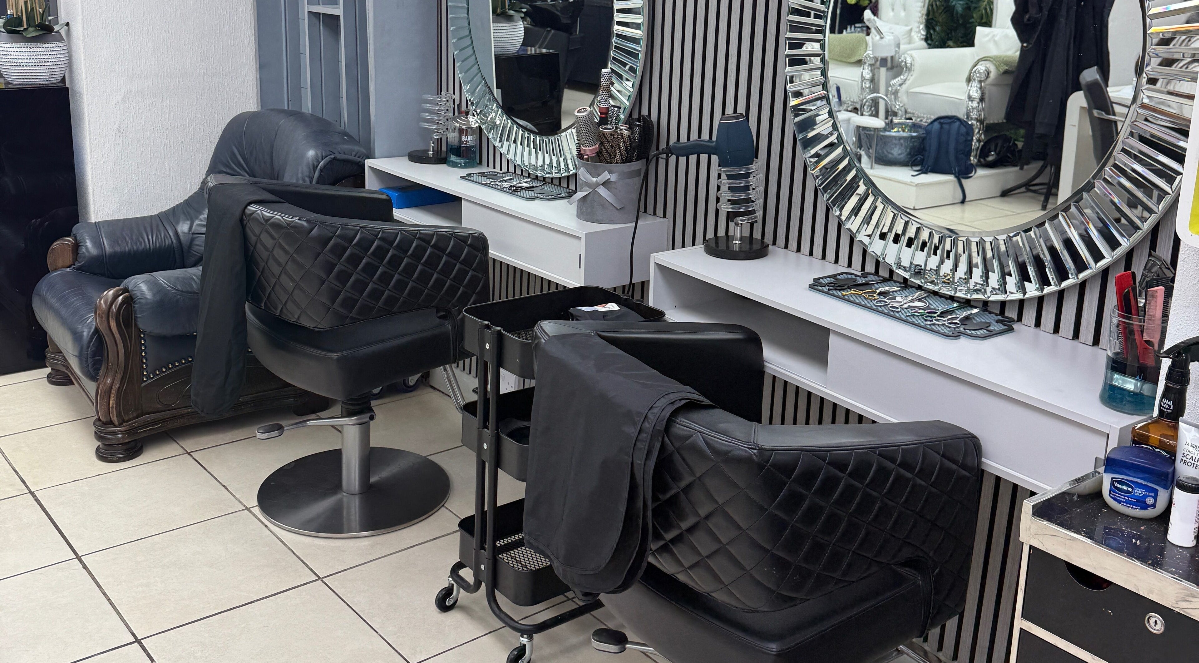 Chic salon chairs beside a mirrored wall at Tandis Boutique, Birmingham, England, GB.