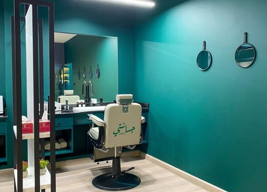 Modern interior of Janti Salon for Men, Doha, with teal walls and stylish barber chair.