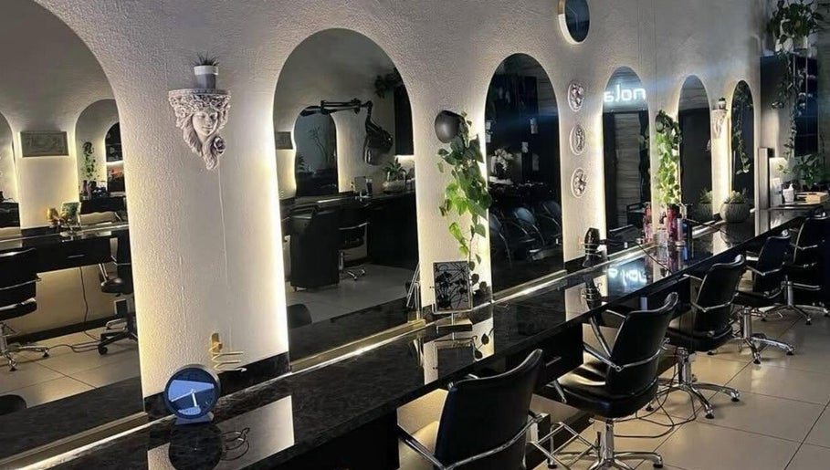 Modern salon interior at Tella The Hybrid Stylist, Pretoria, Gauteng, ZA, featuring sleek black chairs and mirrors.