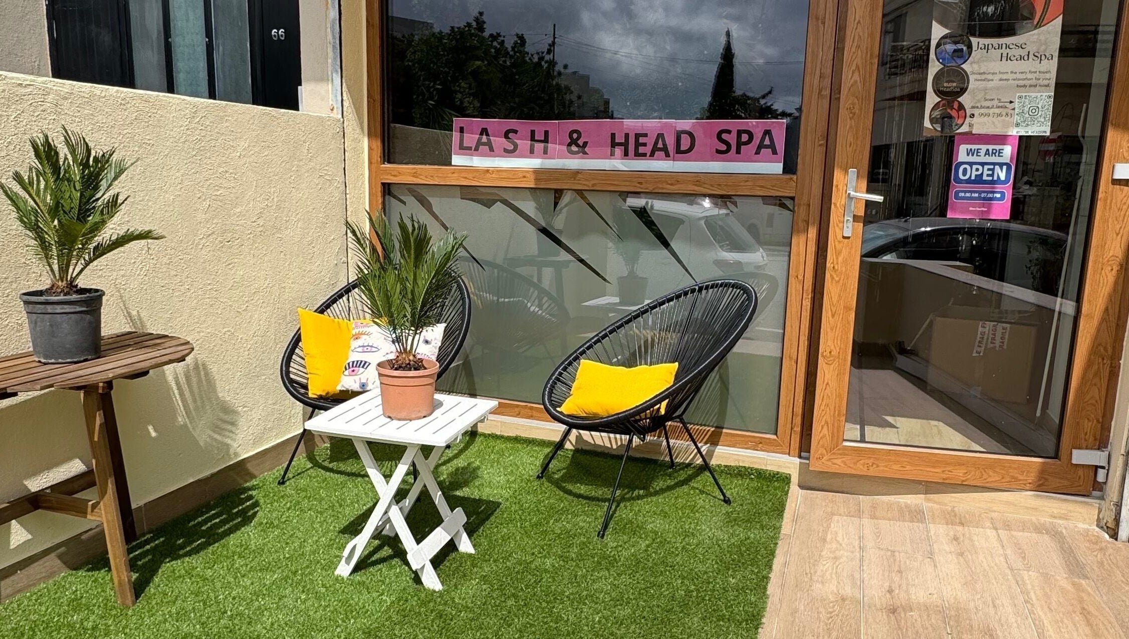 Cozy outdoor seating at GlowHeadSpa, San Pawl Il-baħar, MT with lush plants and stylish chairs.