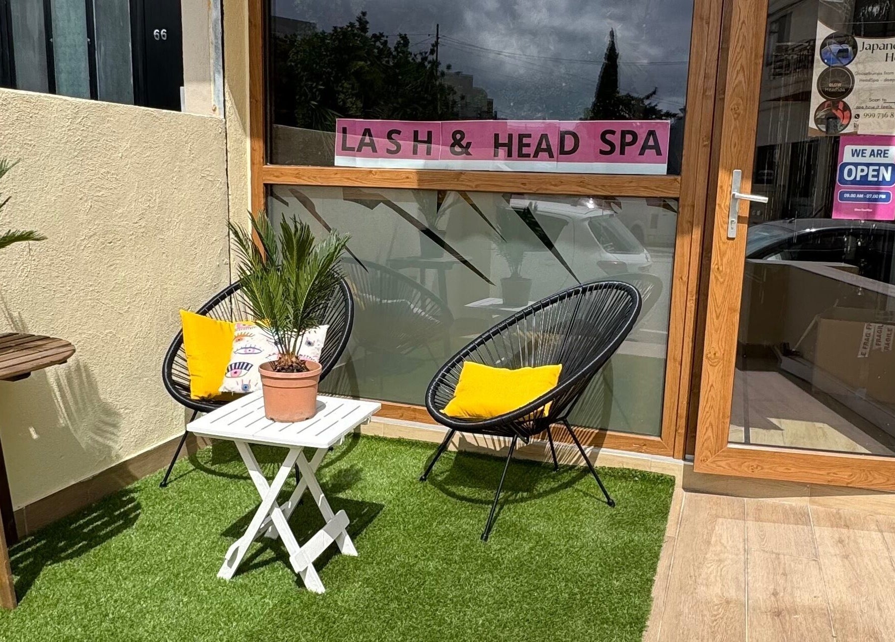 Cozy outdoor seating at GlowHeadSpa, San Pawl Il-baħar, MT with lush plants and stylish chairs.