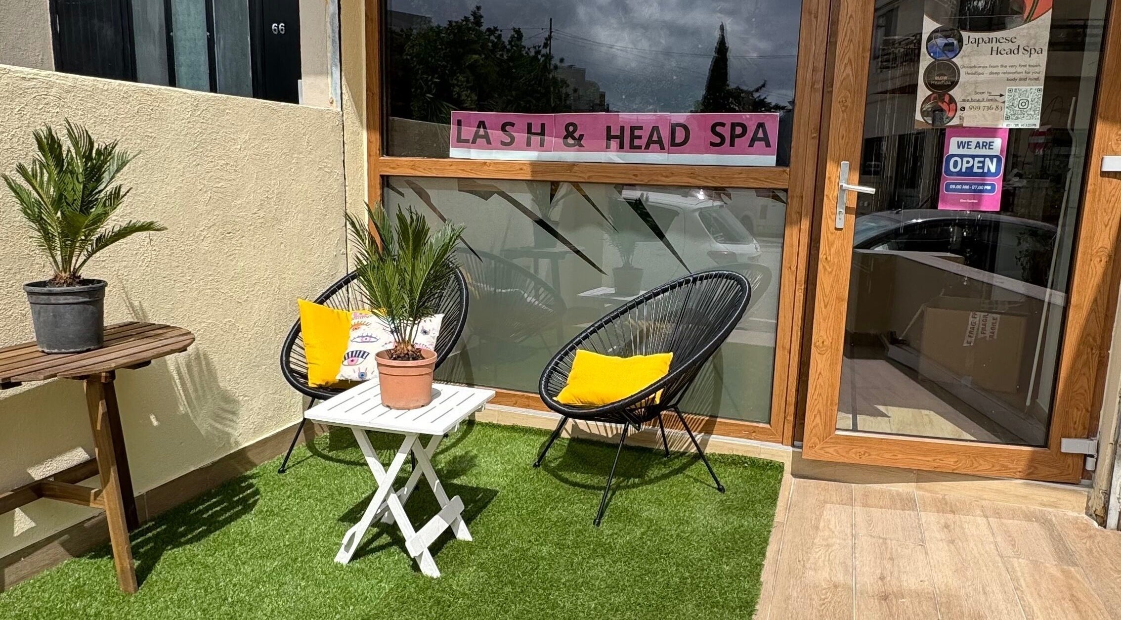 Cozy outdoor seating at GlowHeadSpa, San Pawl Il-baħar, MT with lush plants and stylish chairs.