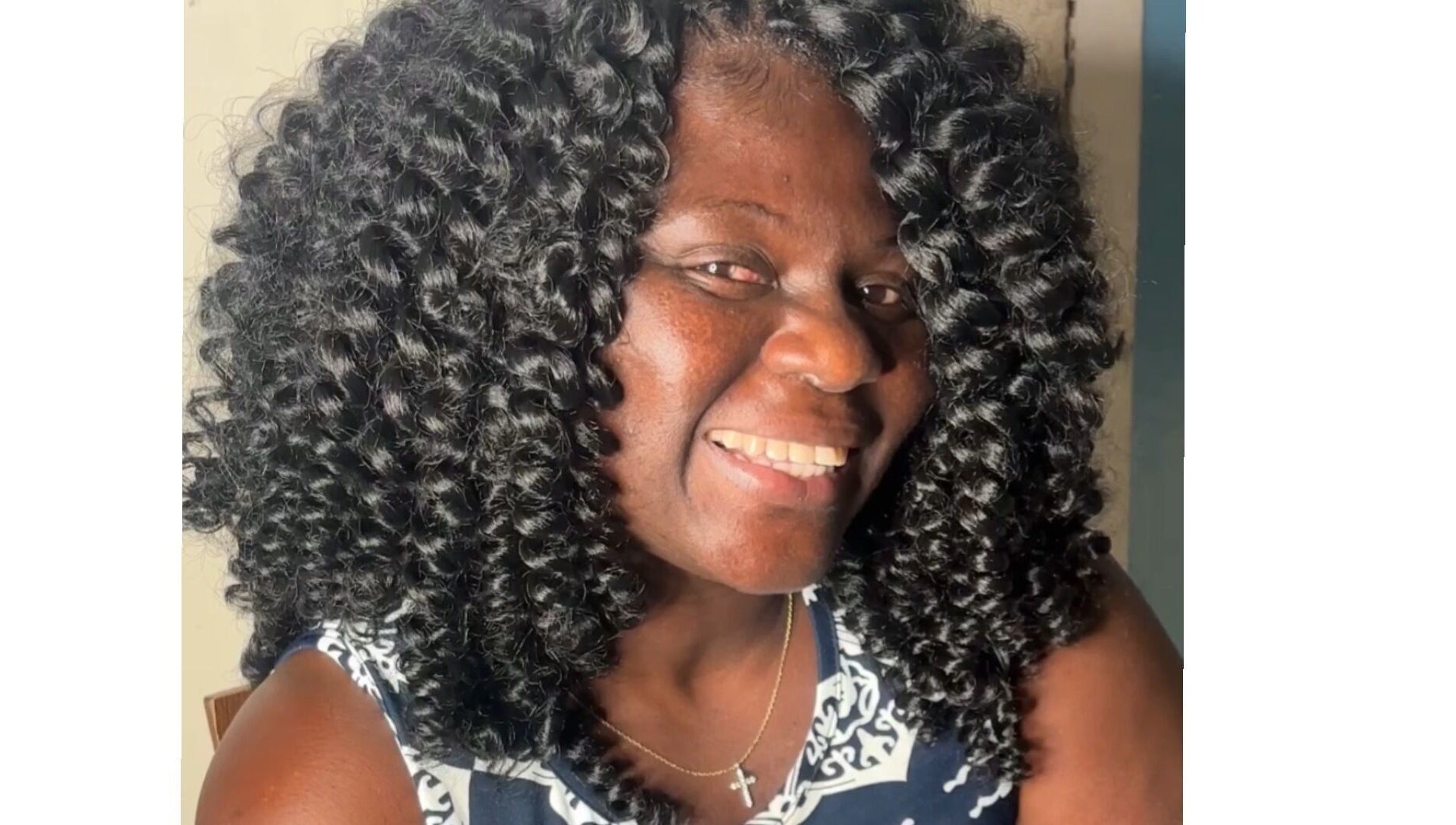 Smiling woman with curly hair at Crownedbycassie, Lauderhill, Florida, US.