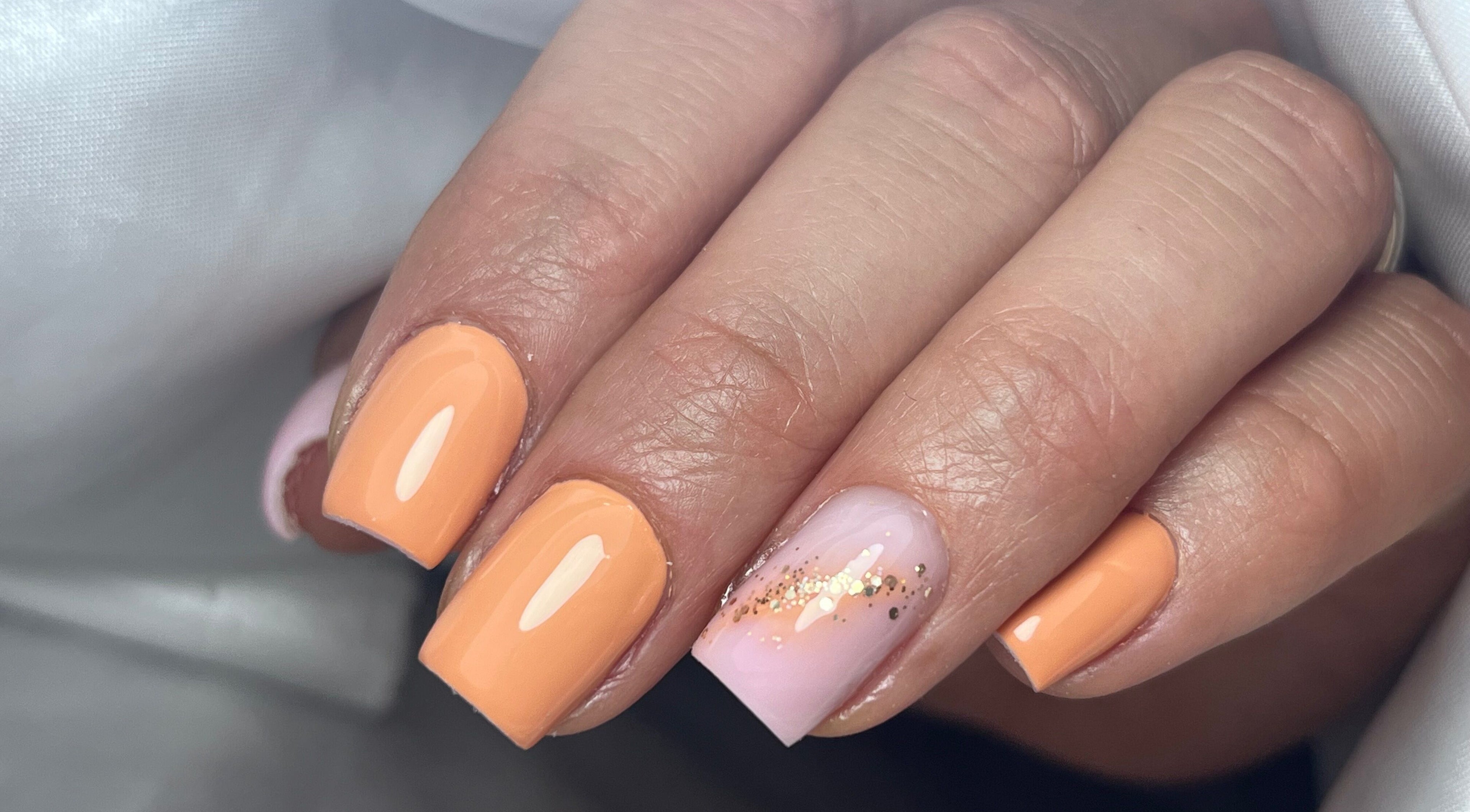 Manucure élégante chez Beauty Studio, Saint-romain-sur-cher, Centre-val De Loire, FR. Ongles orange et pailletés.