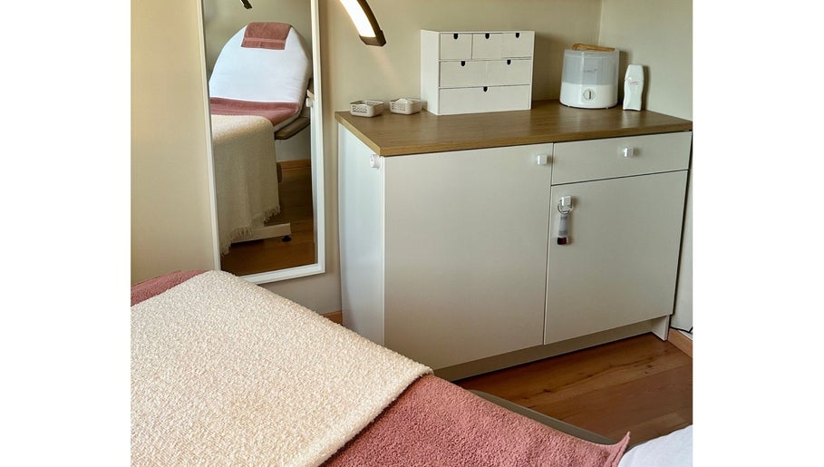 Sfeervolle behandelkamer bij Puur ‘L by Lauren in Bornem, Vlaanderen, BE, met comfortabele stoel en opbergkast.