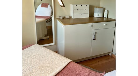 Sfeervolle behandelkamer bij Puur ‘L by Lauren in Bornem, Vlaanderen, BE, met comfortabele stoel en opbergkast.