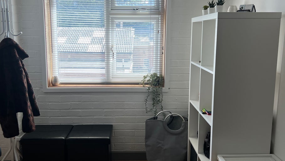 Bright and cozy interior of LP Sports Therapy in Burbage, England, GB, featuring a window and organized shelving.
