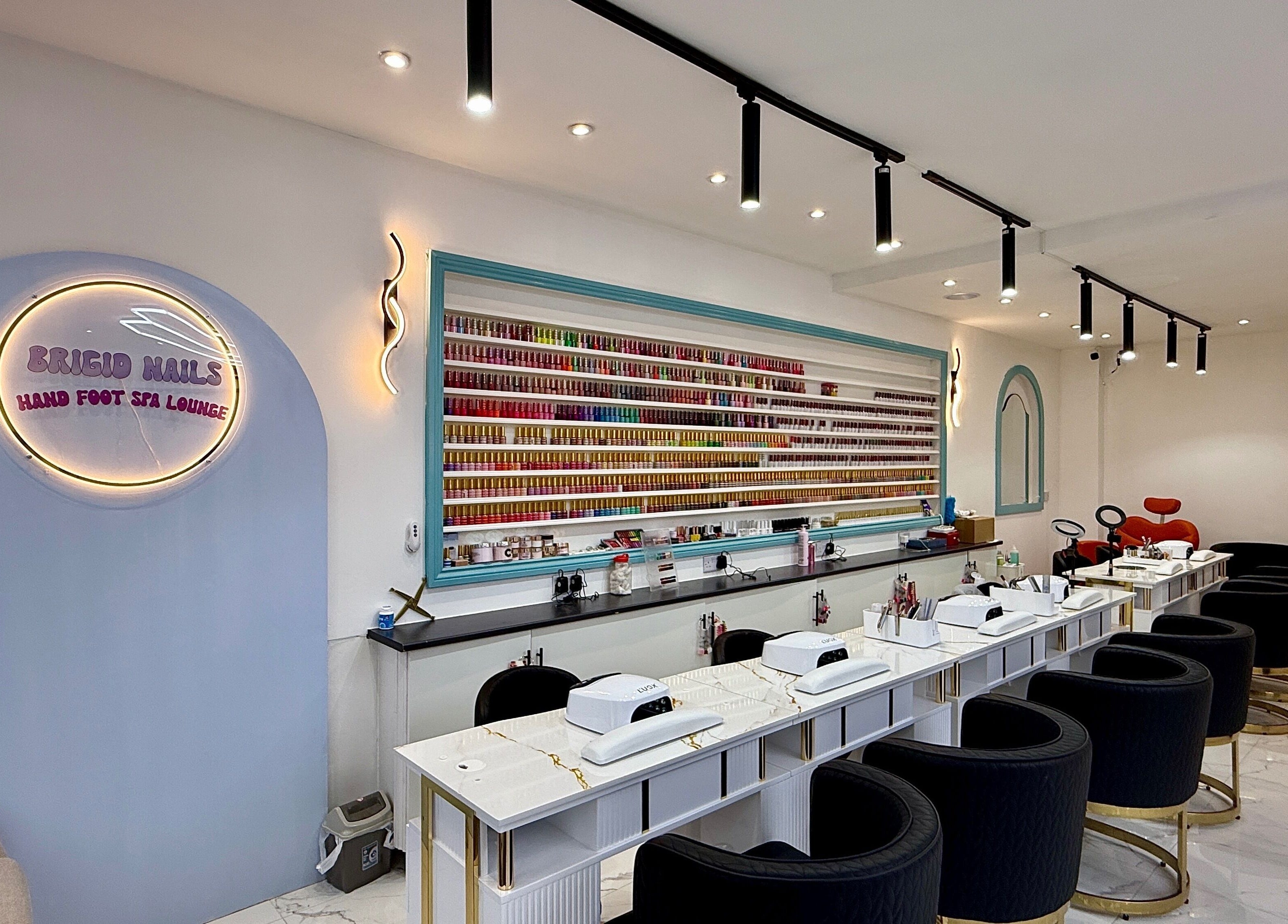 Elegant interior of Brigid Nails, Monaghan, County Monaghan, IE, showcasing plush seating and nail polish display.