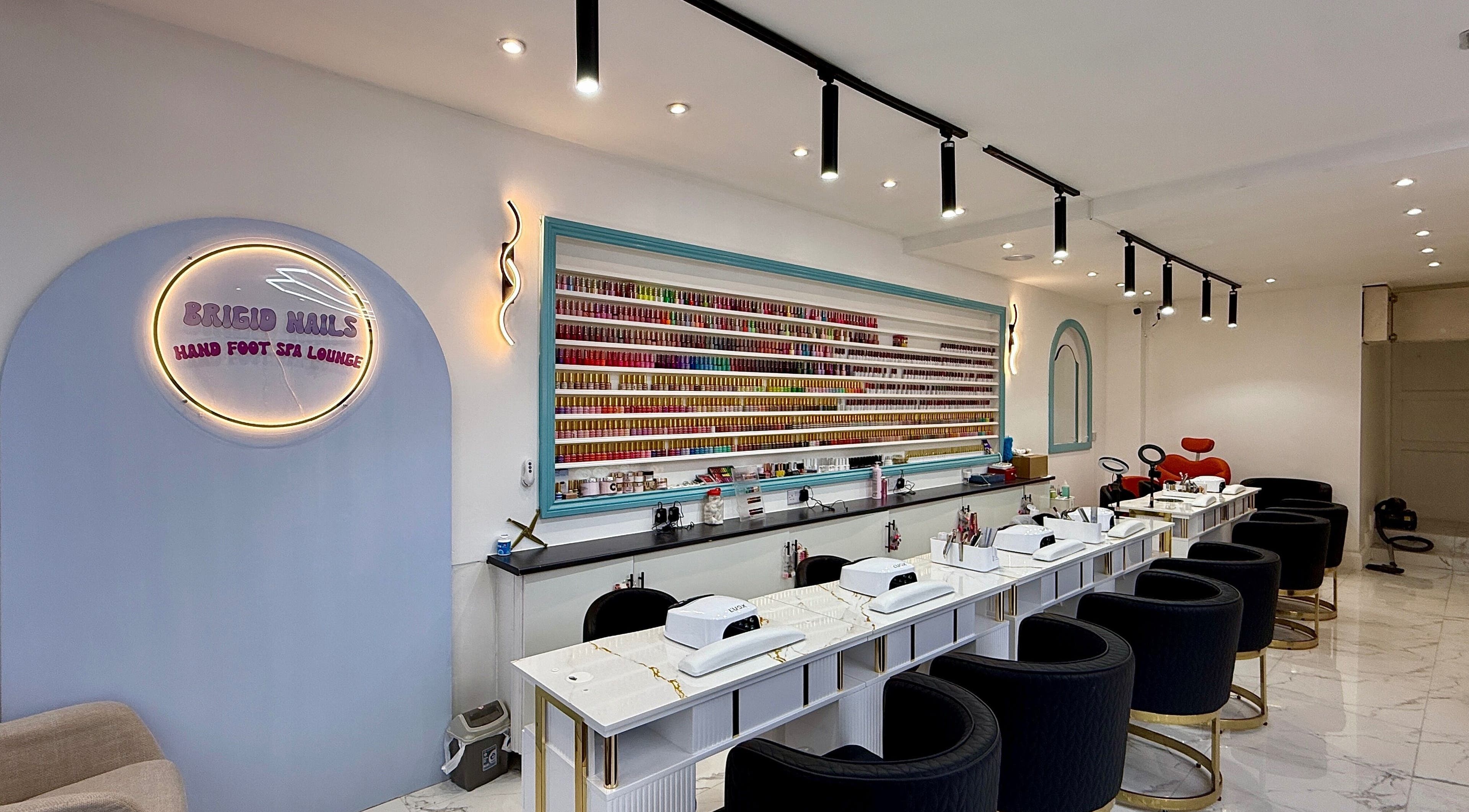 Elegant interior of Brigid Nails, Monaghan, County Monaghan, IE, showcasing plush seating and nail polish display.