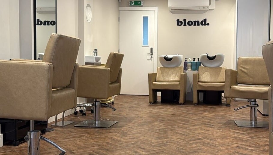 Modern salon interior at Natasha Ellen Hair, Sarisbury Green, England, GB, featuring sleek chairs and washing stations.