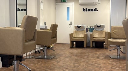 Modern salon interior at Natasha Ellen Hair, Sarisbury Green, England, GB, featuring sleek chairs and washing stations.