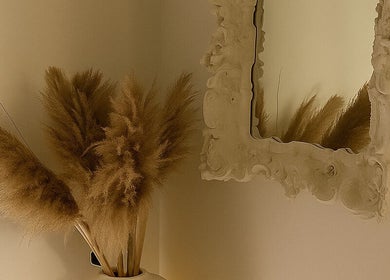 Elegant mirror and dried flowers at Noble Men's Spa, New York, New York, US, create a vintage aesthetic.