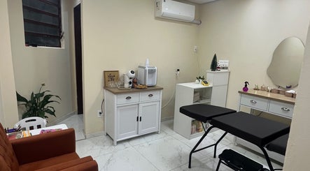 Sala aconchegante do Ateliê Milene Ribeiro, Rio Grande do Sul, BR, com sofá, plantas e equipamentos de beleza.
