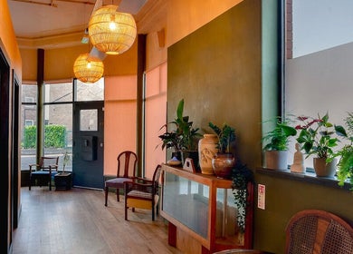 Inviting interior of Soma Body Studio, Manchester, England, GB with warm lighting and green plants.