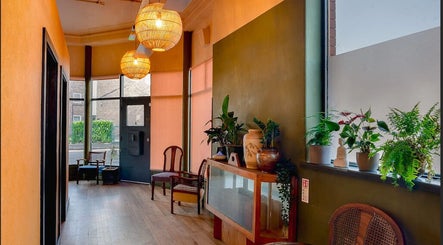 Inviting interior of Soma Body Studio, Manchester, England, GB with warm lighting and green plants.