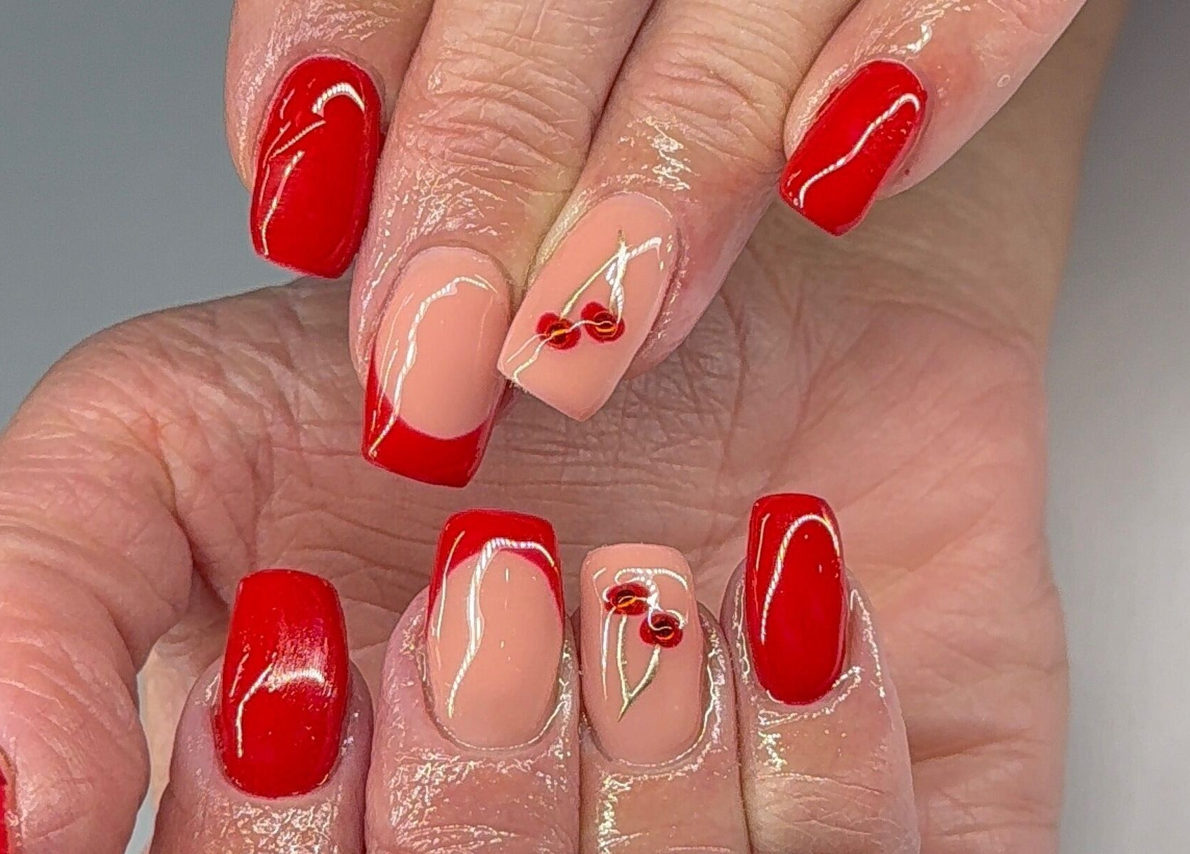 Stylish red and nude cherry nail art at Nikki Nails, Llansamlet, Wales, GB.