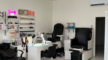 Chic nail lounge at Belleza Glam Studio, South Gate, California, US featuring stylish seating and nail polish display.