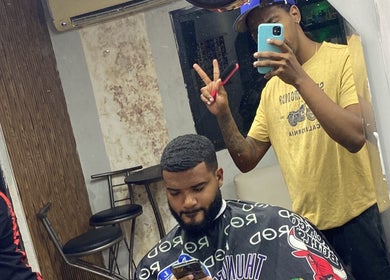Barber styling client's hair at The Feoh barbershop in Santo Domingo Este, Santo Domingo, DO.