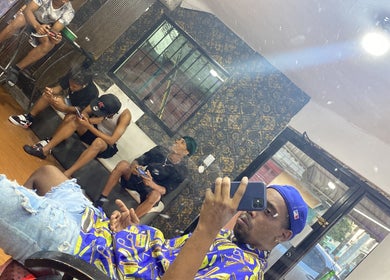 Relaxed atmosphere at The Feoh barbershop, Santo Domingo Este, Santo Domingo, DO, with clients waiting.