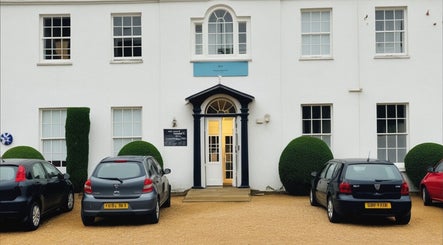 Entrance of Louisa Sales Malia Organics in Christchurch, Hampshire Dorset, GB with parked cars.