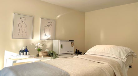 Serene massage room at Louisa Sales Malia Organics, Christchurch, Hampshire, GB with calming artwork.