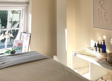Sunlit massage room at Louisa Sales Malia Organics, Christchurch, Hampshire, GB, with serene decor.