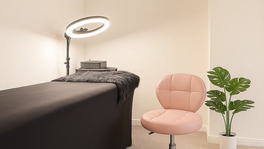 Modern treatment room at LuxeLine Aesthetics, Woodford Green, England, featuring a plush chair and elegant decor.