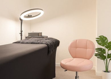 Modern treatment room at LuxeLine Aesthetics, Woodford Green, England, featuring a plush chair and elegant decor.