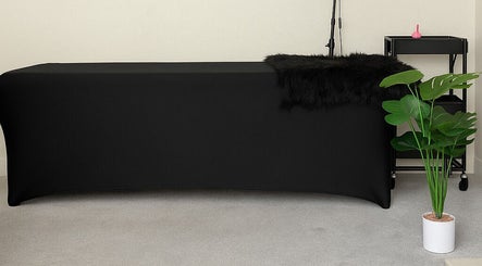 Elegant treatment room at LuxeLine Aesthetics, Woodford Green, England, GB, featuring a black massage table.