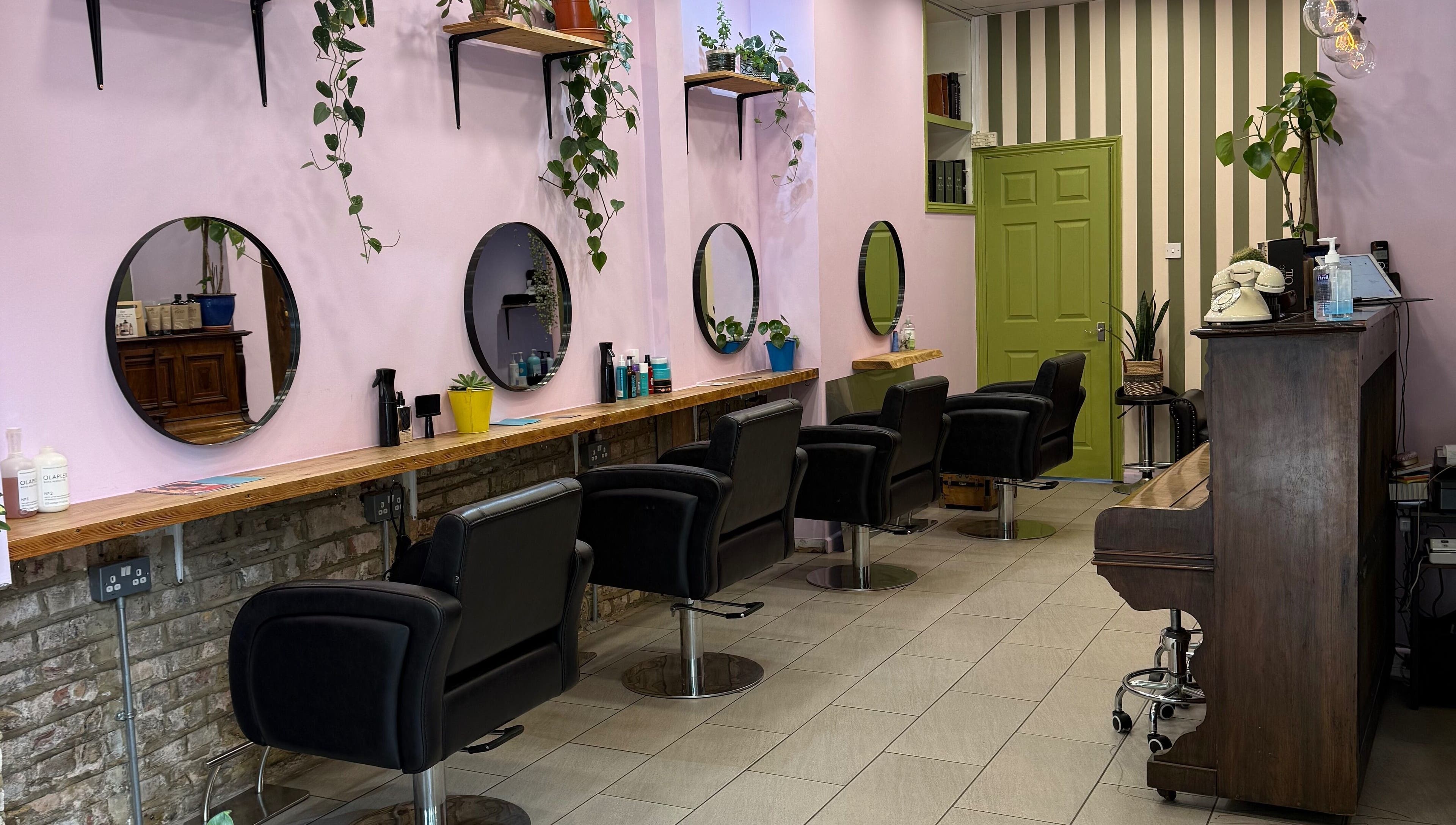 Elegant interior of Cut & Craft salon in London, England, GB with stylish chairs and large mirrors.