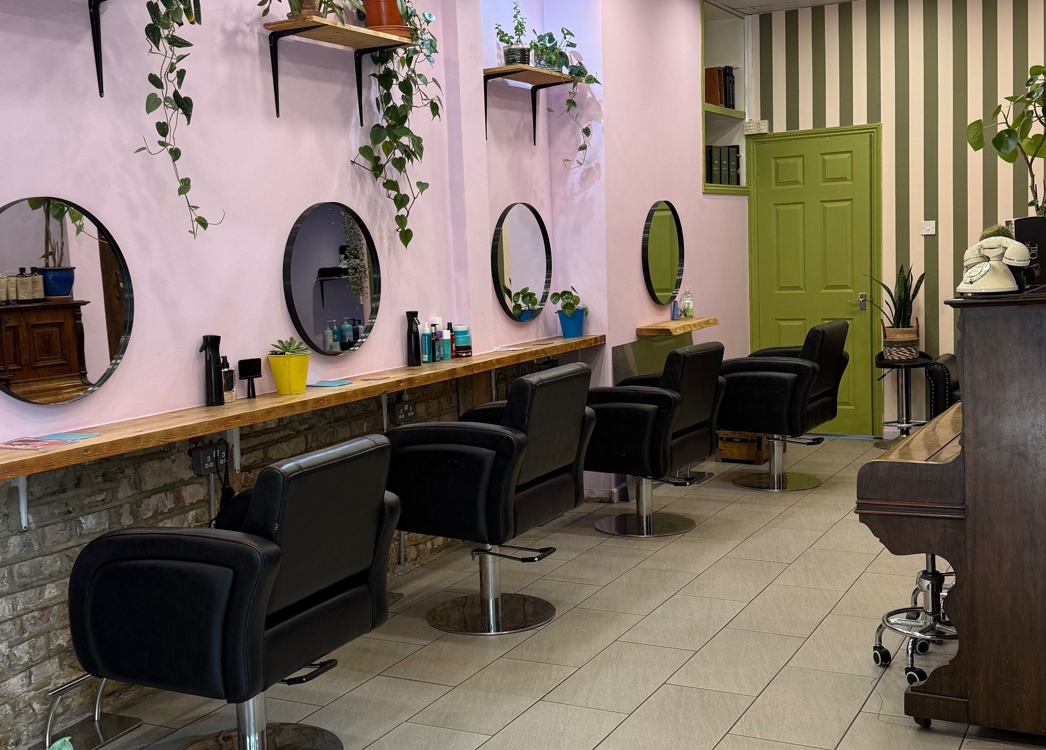 Elegant interior of Cut & Craft salon in London, England, GB with stylish chairs and large mirrors.