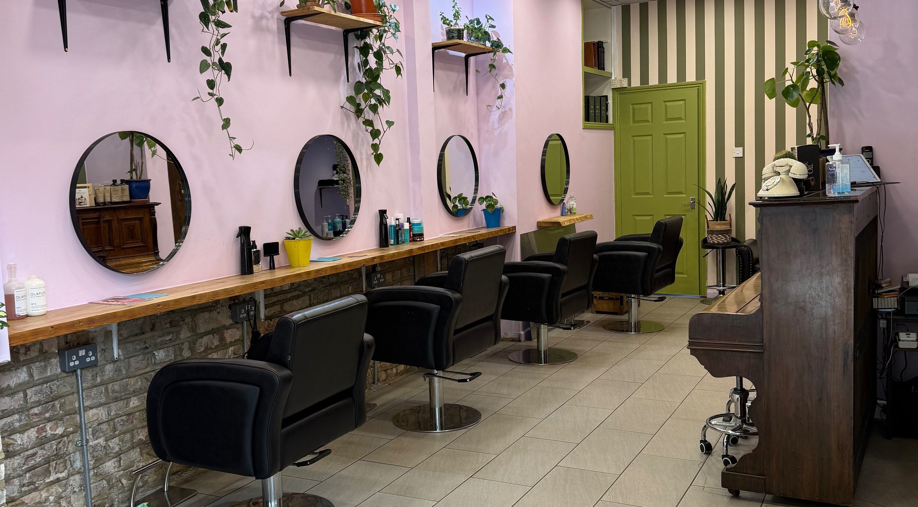 Elegant interior of Cut & Craft salon in London, England, GB with stylish chairs and large mirrors.