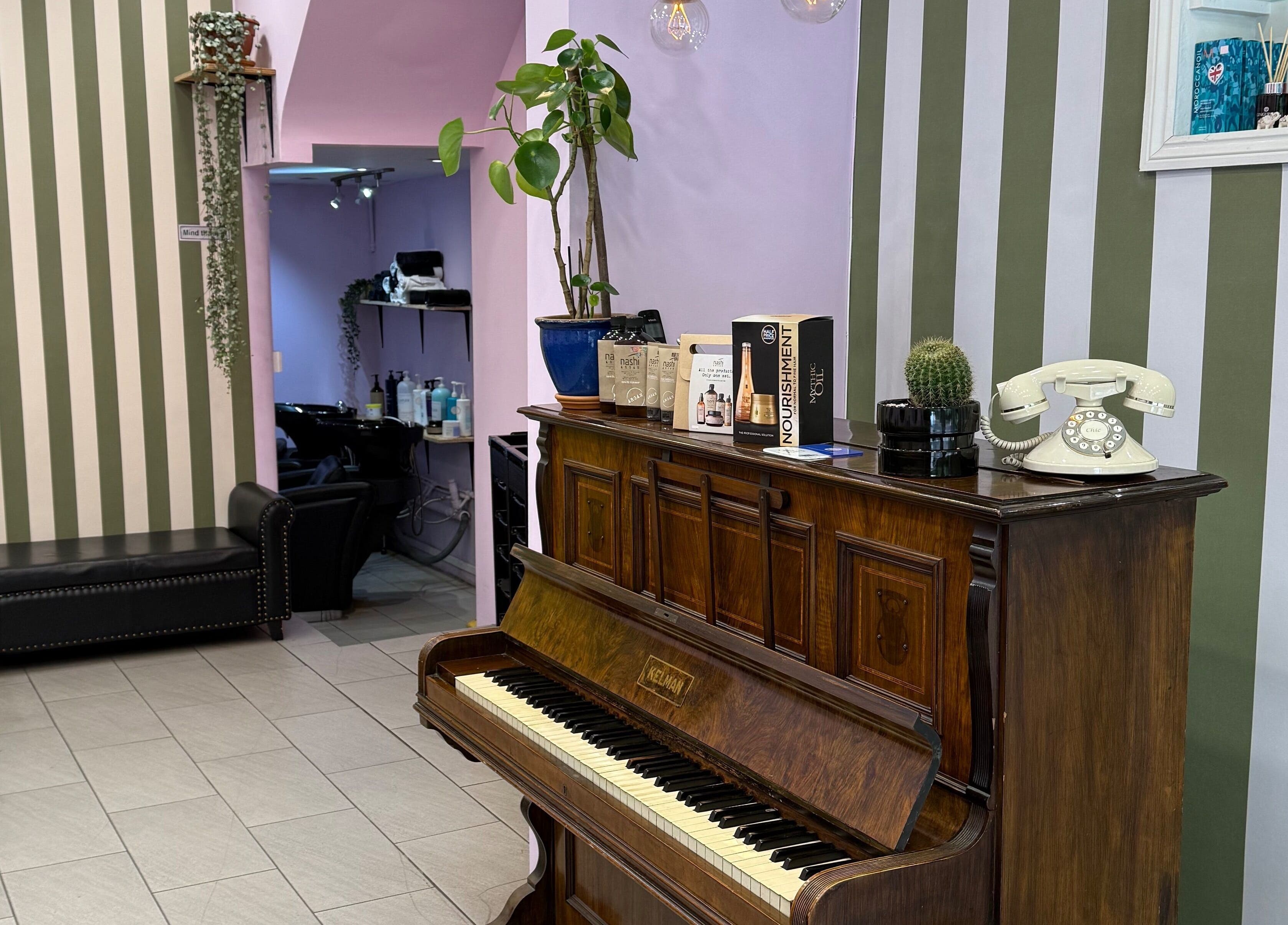 Cut & Craft salon in London, England, GB featuring vintage decor with piano and green plants.