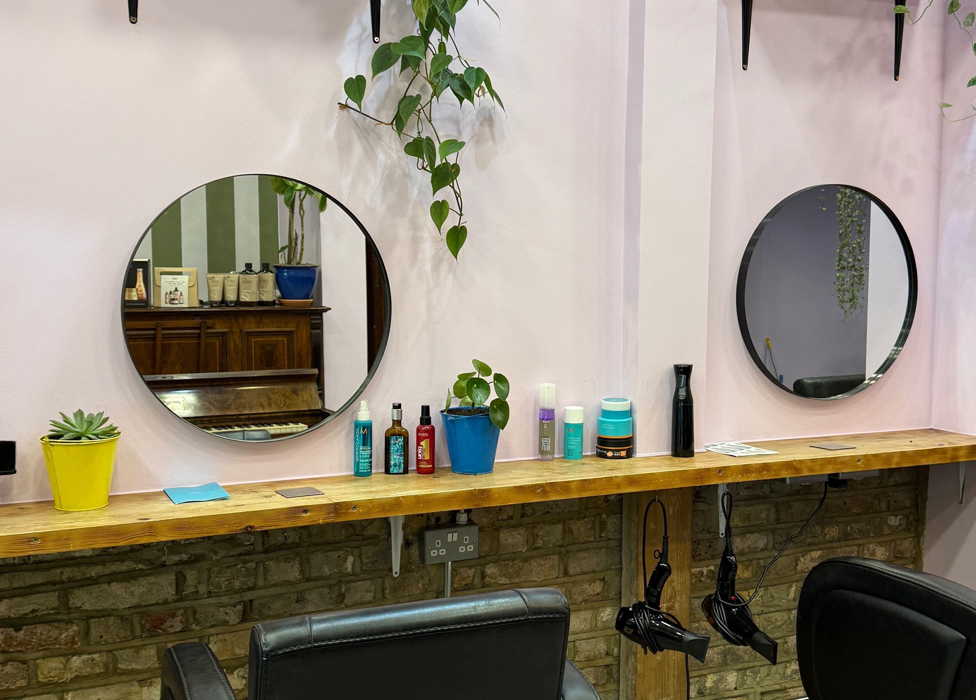 Cut & Craft salon station in London, England, GB with mirrors, plants, and styling tools.