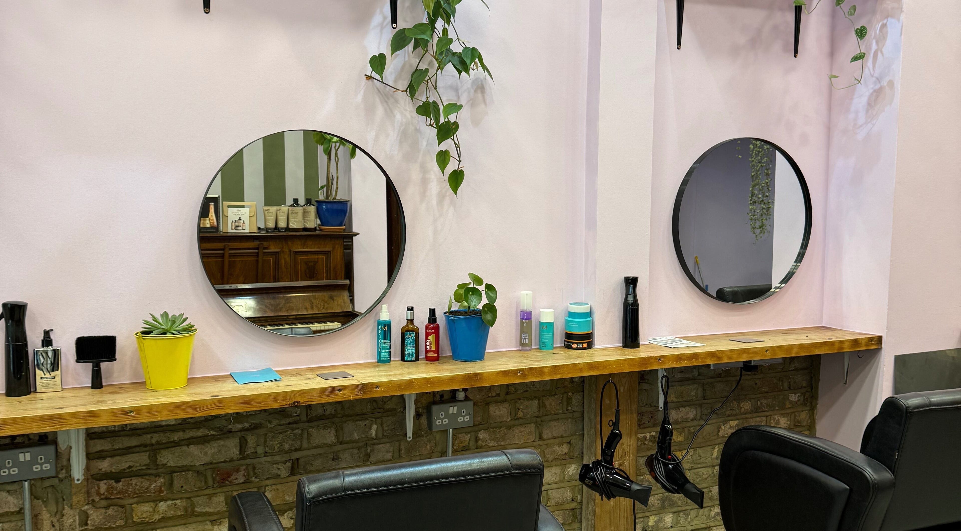 Cut & Craft salon station in London, England, GB with mirrors, plants, and styling tools.