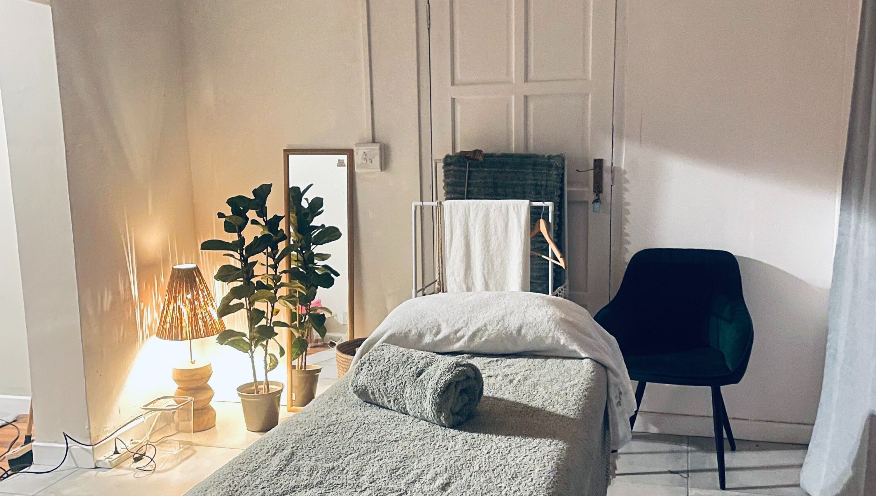 Relaxing massage room at Bliss Therapy, Cape Town, Western Cape, ZA, featuring cozy decor and ambient lighting.