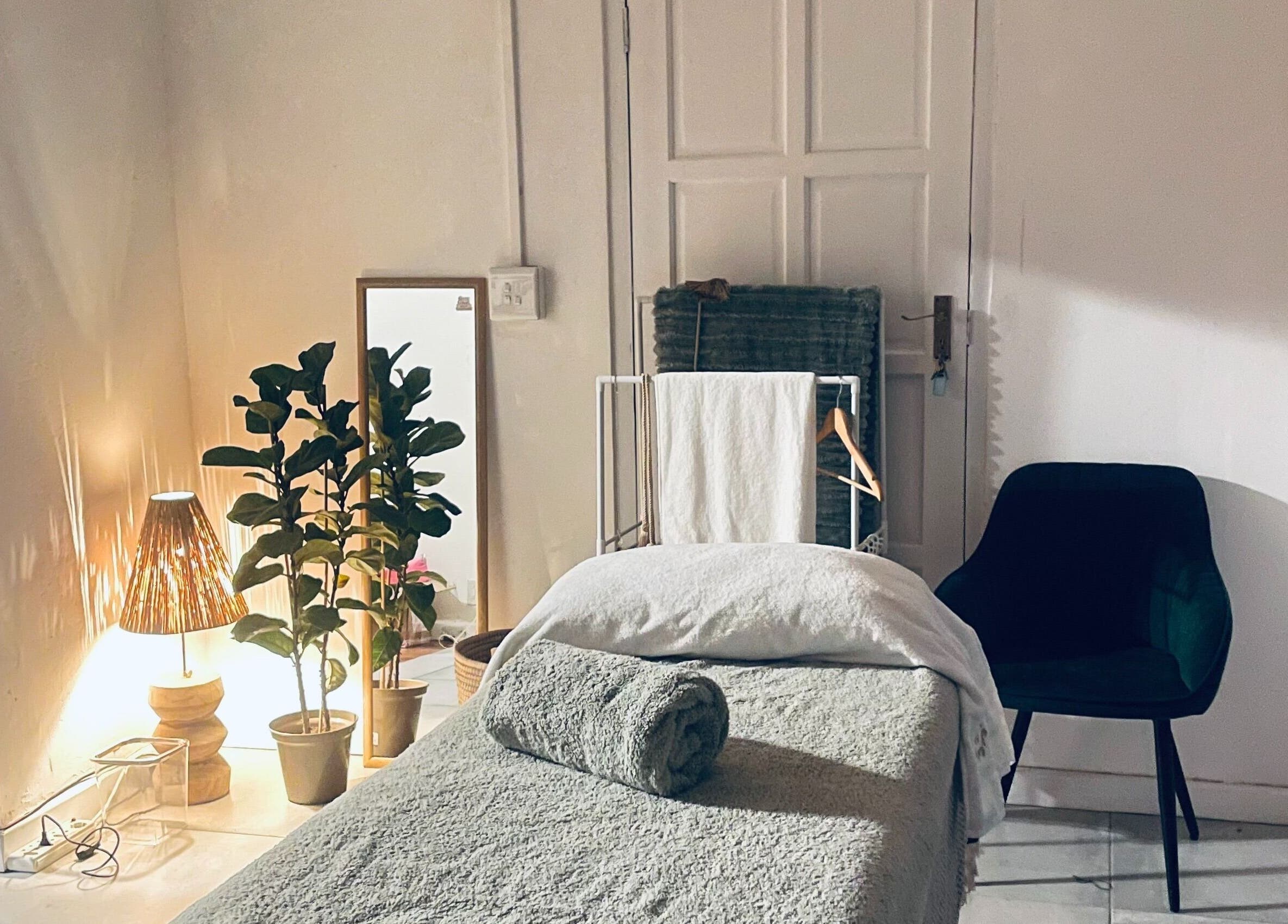 Relaxing massage room at Bliss Therapy, Cape Town, Western Cape, ZA, featuring cozy decor and ambient lighting.