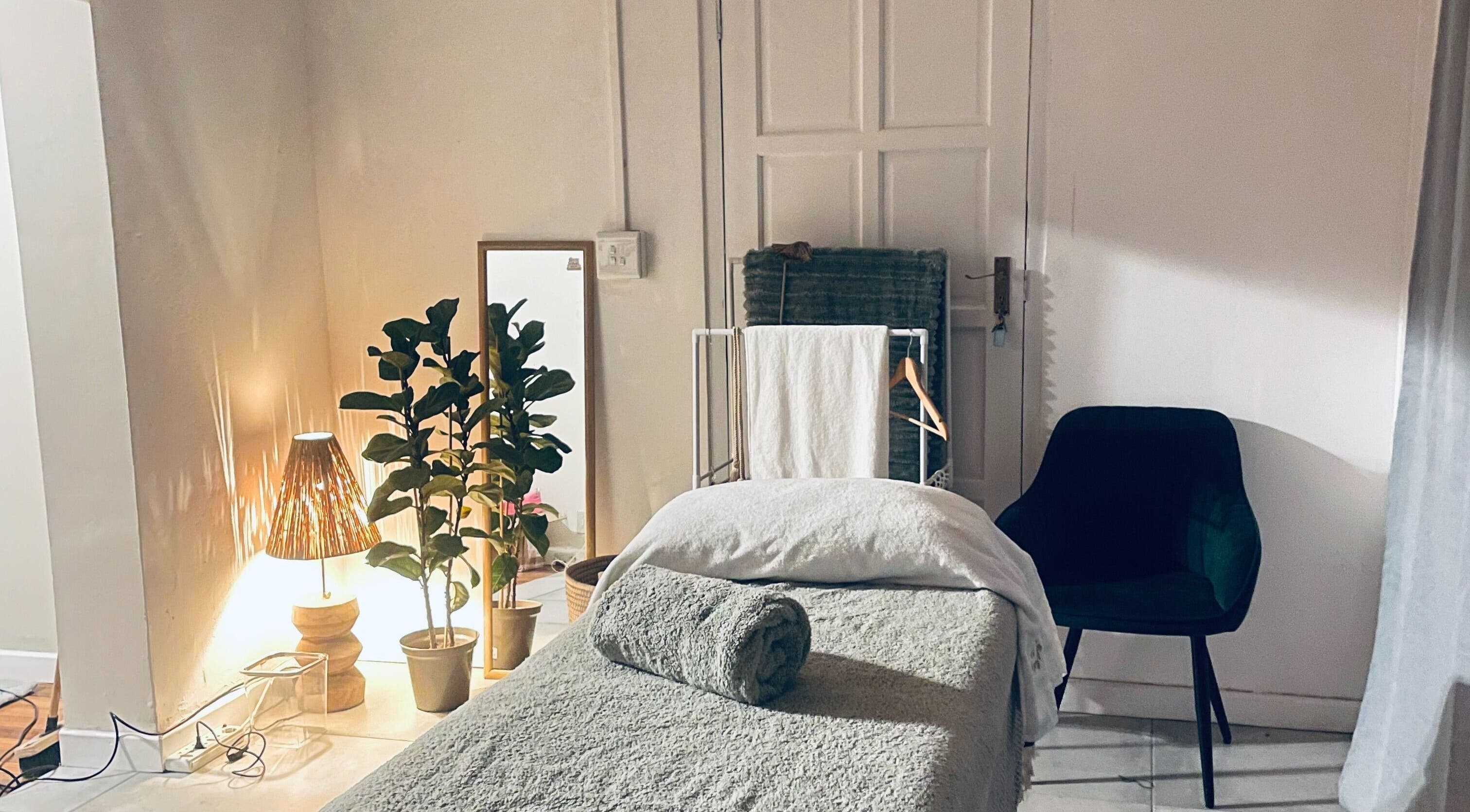 Relaxing massage room at Bliss Therapy, Cape Town, Western Cape, ZA, featuring cozy decor and ambient lighting.