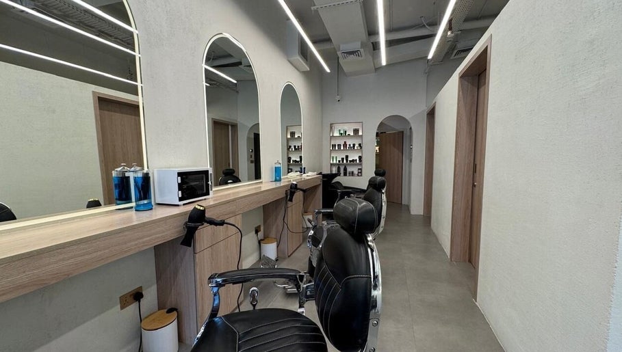 Modern interior of Black Oak Gents Salon in Dubai, Dubai, AE with stylish barber chairs and product shelves.