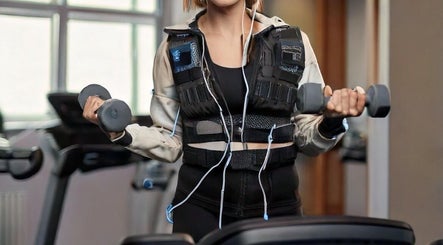Allenamento EMS al Fit And Go Cinque Giornate, Milano, Lombardia, IT con donna che usa pesi.
