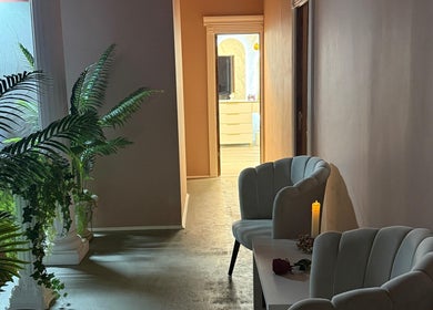 Interior elegant la Elysia Beauty Lounge, București, cu fotolii și plante verzi.