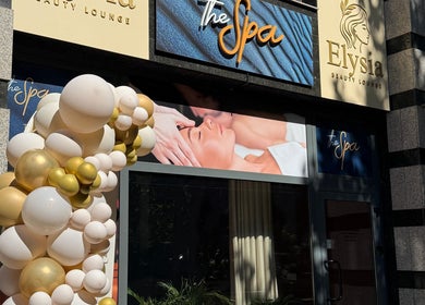Intrarea Elysia Beauty Lounge din București, decorată cu baloane elegante.