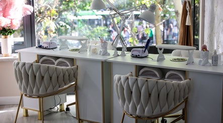 Interior modern al salonului Elysia Beauty Lounge București, București, RO, cu scaune elegante și mese de manichiură albe.