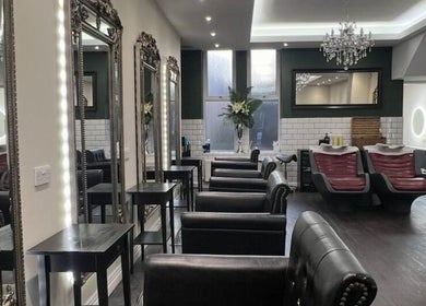 Chic interior of Newcastle Hair Company in Newcastle upon Tyne, showcasing plush chairs and ornate mirrors.